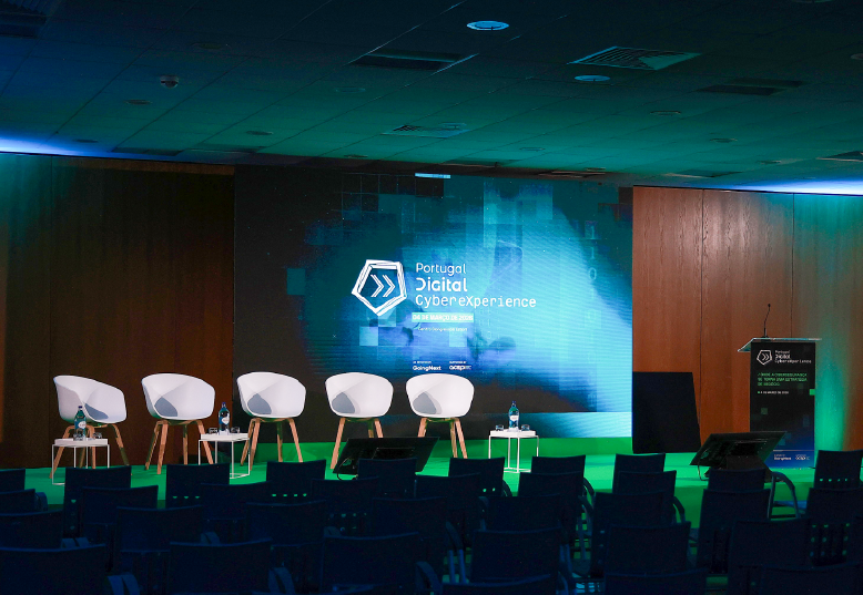 Palco do Auditório 2 com alcatifa verde e mobiliário