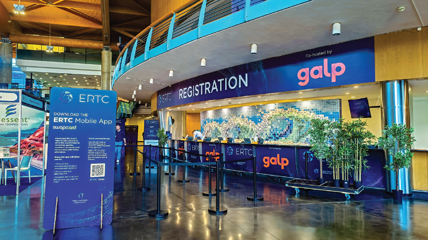 Área de receção decorada com grafismo do evento ERTC e suportes informativos