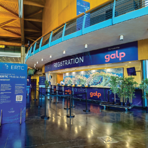 Área de receção decorada com grafismo do evento ERTC e suportes informativos