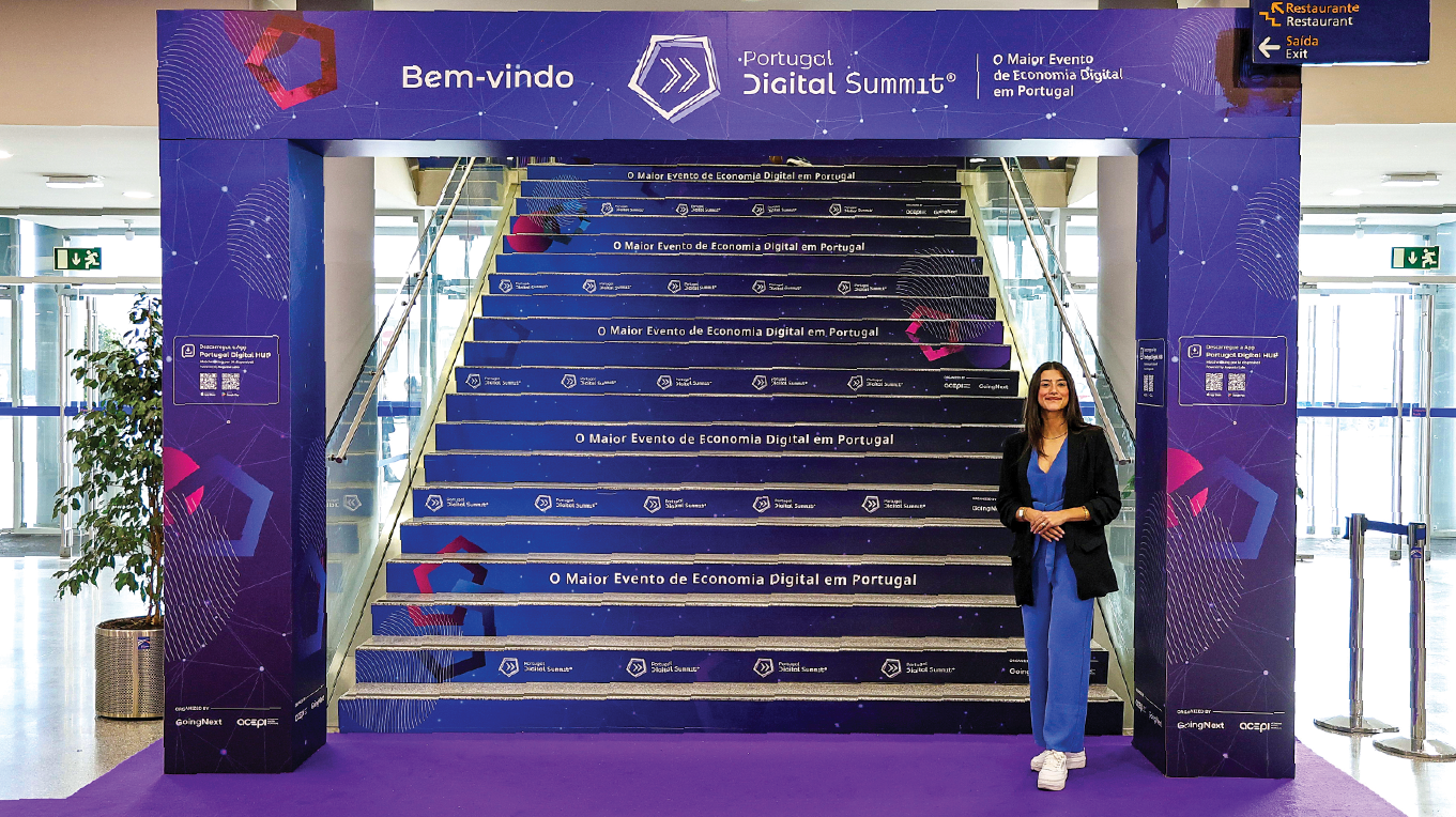 Percurso entre check-in e área de exposição com escadaria decorada e carpete