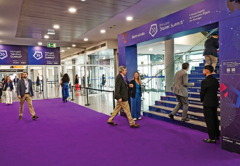 Percurso entre check-in e área de exposição com escadaria decorada e carpete