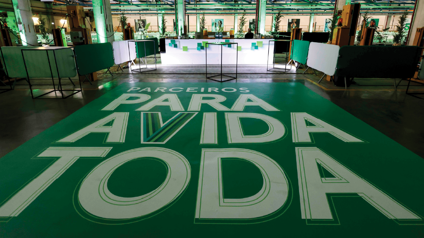 Vinil de chão com grafismo da marca Tranquilidade aplicado em espaço de evento corporativo