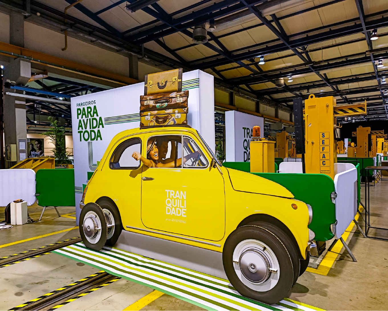 Estrutura cenográfica com carro amarelo e grafismo da Tranquilidade, reforçando identidade visual da marca no evento