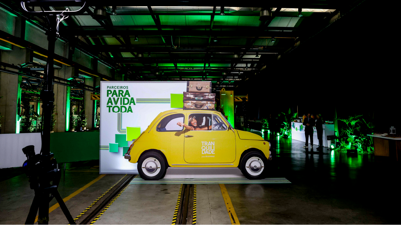 Carro em cartão decorativo com branding Tranquilidade durante evento corporativo de design